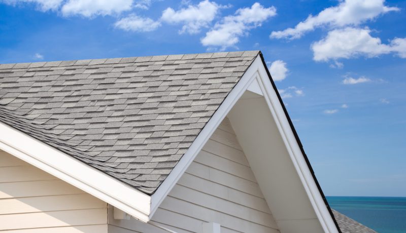 grey roof shingle with blue sky background, house roof near sea in morning time.