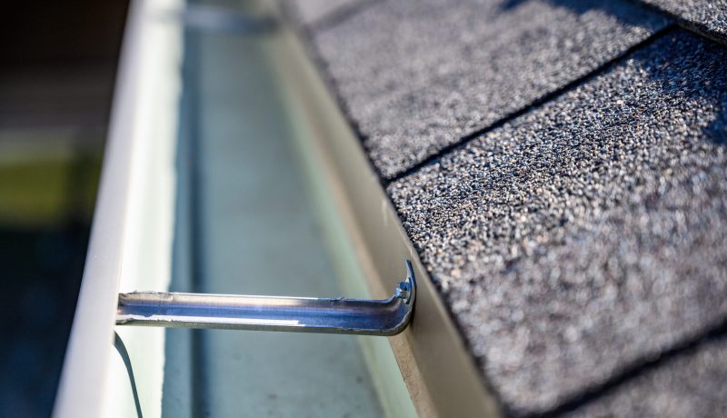 view inside roof gutter with clips and edge of shingles